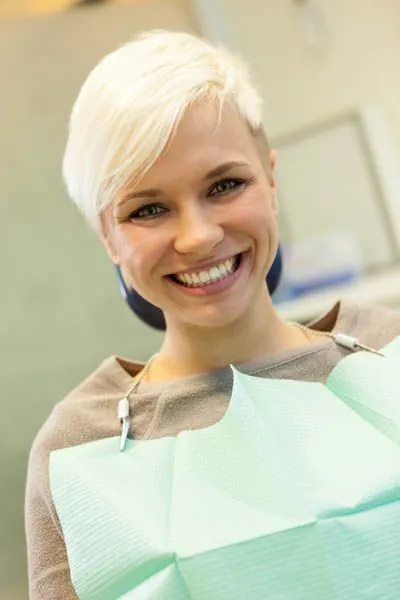 woman showing off her new dental implants she got from Oregon Wisdom Teeth