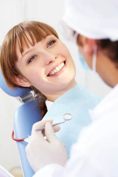 woman getting a checkup after receiving a dental implant at Oregon Wisdom Teeth