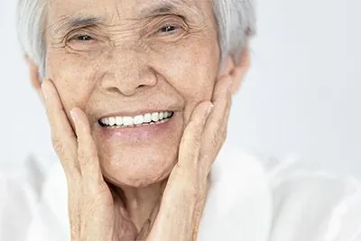 older woman smiling with her new dentures in place