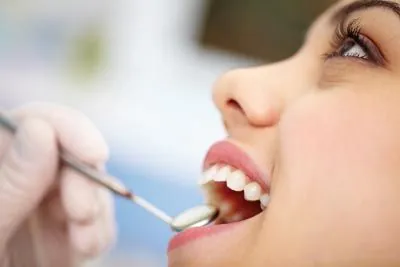 patient getting a checkup after having her wisdom teeth removed